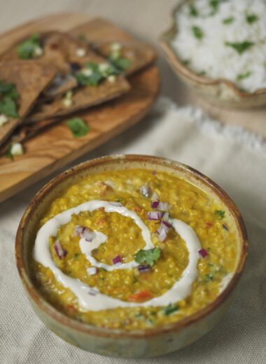bowl of immune boosting flu fighter dal soup with chapati and rice in background