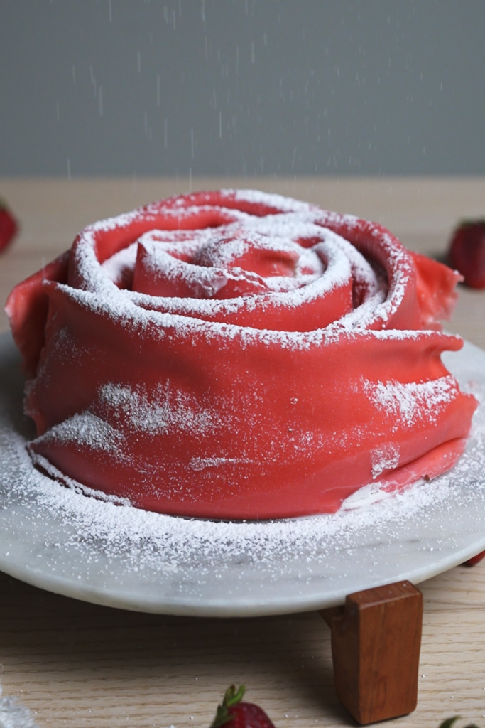 topping rose crepe cake with powdered sugar