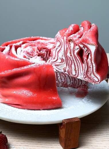 Taking slice of rose crepe cake.